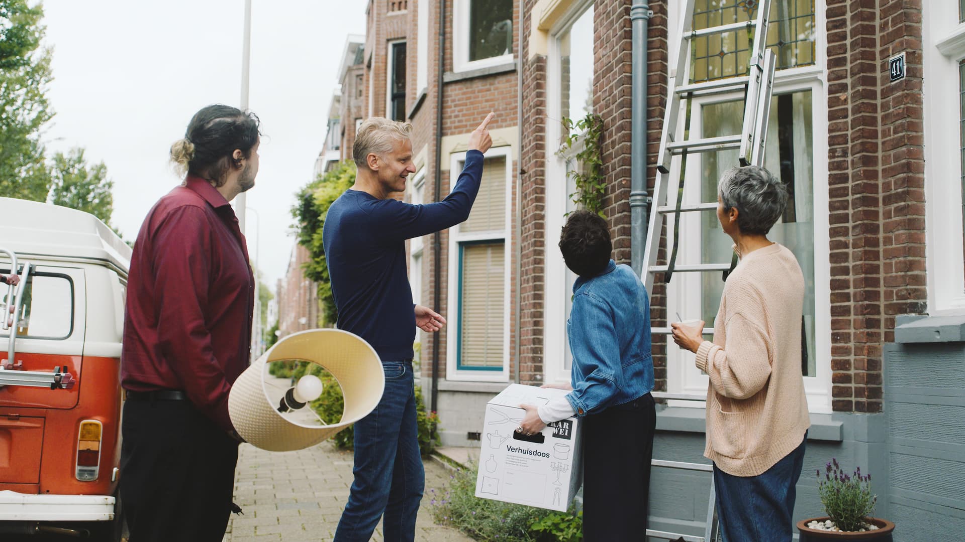 Campagnebeeld: bewoners en verhuizers kijken met een knipoog naar een ladder tegen een huis
